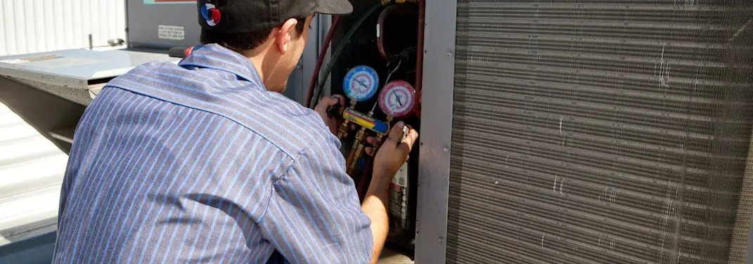 HVAC technician servicing a condenser unit in Bloomingdale